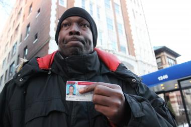  James Barnett holds the driver's license of Charles Roth, 55, outside Astor House in Rogers Park, where Barnett cared for Roth, who died about two weeks ago, before they were both evicted Friday. 
