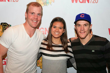  High school freshman Liz Spurlock has custom-painted Blackhawks logos on Converse All-Stars shoes. Here Spurlock is shown with two of her favorite players, Bryan Bickell (l.) and Andrew Shaw. 
