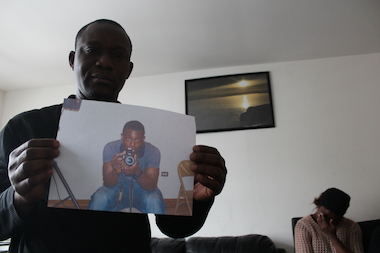  Akwasi Yeboah holds a photo of his 23-year-old son, Orduro, who was shot to death Monday afternoon. 