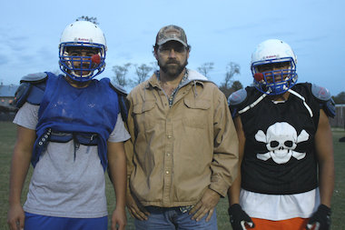  Curie assistant coach Doug Bartlett, who was a defensive end for the Philadelphia Eagles, is shown with two of his players, Angel Magna (l.) and Jamie Salis. Curie faces New Trier on Saturday in an IHSA Class 8A second-round playoff game in Winnetka. 