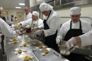  Inmates at Cook County Jail prepare a meal under the direction of chef Bruno Abate (at rear). 