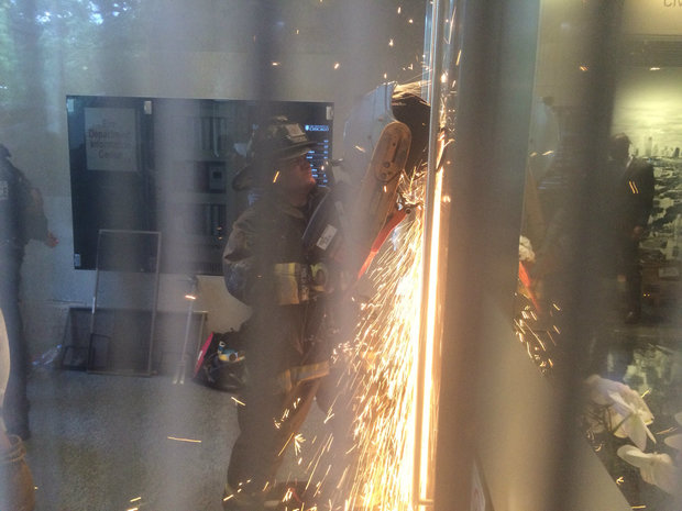  A Chicago firefighter cuts through a bike lock that protesters used to barricade themselves in a U. of C. administration building. 