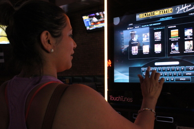  Cindy Calderon of Belmont Cragin looks through the catalog of a TouchTunes machine at Mother Hubbards, a River North bar. 