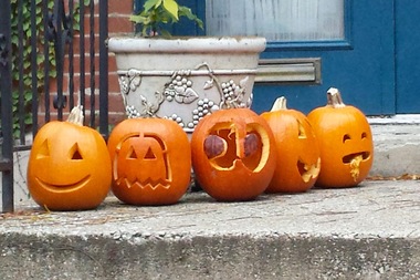  A Wicker Park porch sporting several carved pumpkins. 