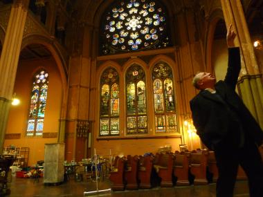  Pastor Daniel Meeter points out stained glass windows in the sanctuary at Old First Reformed Church, which has been housing the Hurricane Sandy Relief Kitchen since November 2012. 
