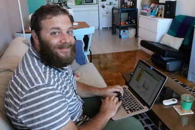  Brooklyn resident Barry Hott, 27, poses after checking out his air conditioner usage on his laptop, using a wireless system provided by Con Edison and NYC-based tech company ThinkEco. 