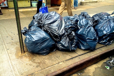  Stacked bags of garbage ooze onto a sidewalk in Chinatown. 