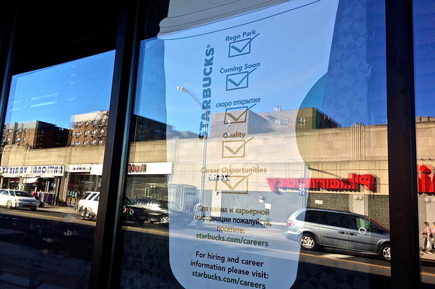  A bilingual poster placed in the window of a new Starbucks opening in Rego Park this weekend.  