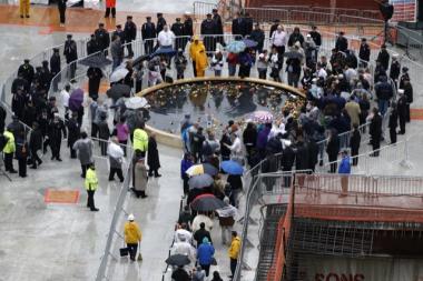 Family members put roses and tulips into a reflecting pool at ground level in the World Trade Center site.  The eighth anniversary of the 9/11 terror attacks was the first year the family members weren't allowed down into the lower levels of the site, known as the pit.
