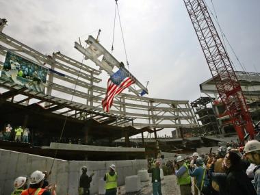 Construction workers read some of the graffiti written on the final steel beam before it was hoisted into place during construction of the new Yankee Stadium on May 1, 2008.