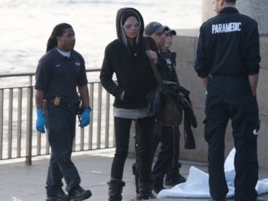 Water drips from a woman's handbag and off her jacket after she climbed into the Hudson River Tuesday afternoon.