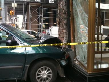 A green minivan blocks the front of a Coach store after crashing into it on Madison Avenue on Wednesday.