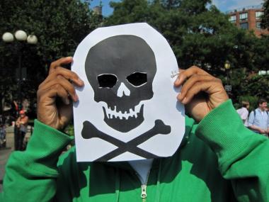 BP protester Paul Mcfarlane holds up a mask meant to highlight the environmental impact of the Gulf oil spill on Thursday, June 10, 2010.