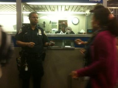 A police officer distributes transfer tickets to commuters, after downtown 1 and 2 trains stalled at the 96th Street station around 6 a.m. Friday morning.