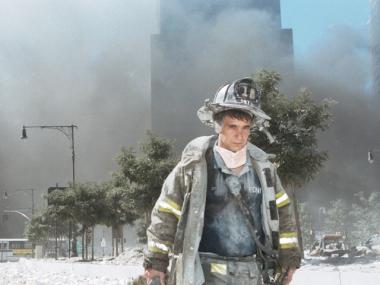 An unidentified firefighter stood near Ground Zero on 9/11, surrounded by dust and ash.