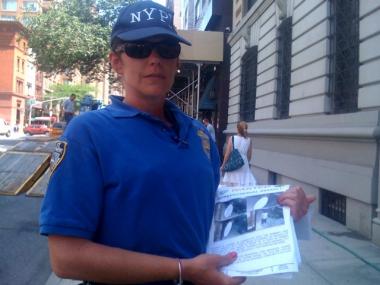 A police officer hands out flyers Tuesday urging help in finding the attacker.