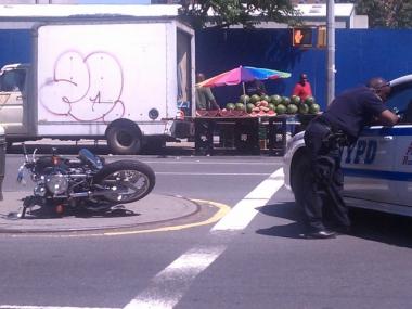 Cops examine the aftermath of a crash that injured a motorcyclist at W. 146th Street and Adam Clayton Powell Blvd.